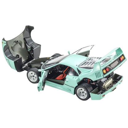 A mint green diecast model car of a Ferrari F40 with its doors and hood open, showing detailed interior and engine compartments, set against a plain white background.