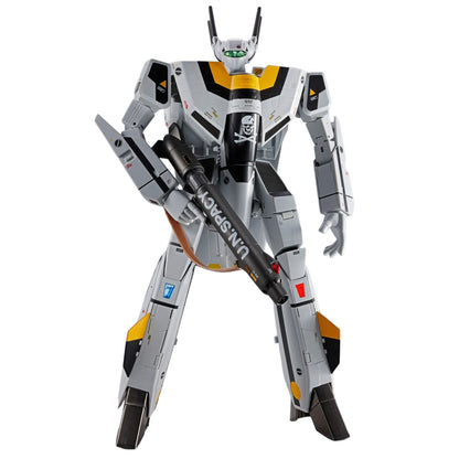 A detailed VF-1S Valkyrie from Macross action figure or collectible robot model in a standing pose, holding a large black weapon. The robot is primarily gray with black and yellow panels, and features visible text including 'U.N.SPRAY'.