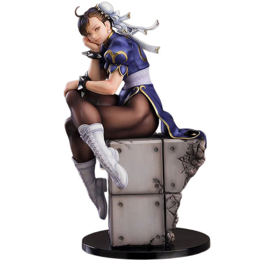 A detailed collectible figurine of Chun-Li from Street Fighter, posed sitting on a cracked stone pedestal. She is wearing her signature blue and gold outfit, brown stockings, and white boots, set against a plain white background.
