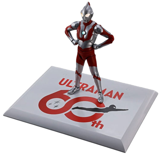 Ultraman 60th Anniversary collectible figure standing on a matching display base. The figure is detailed in silver and red with white eyes, posed with hands on hips.